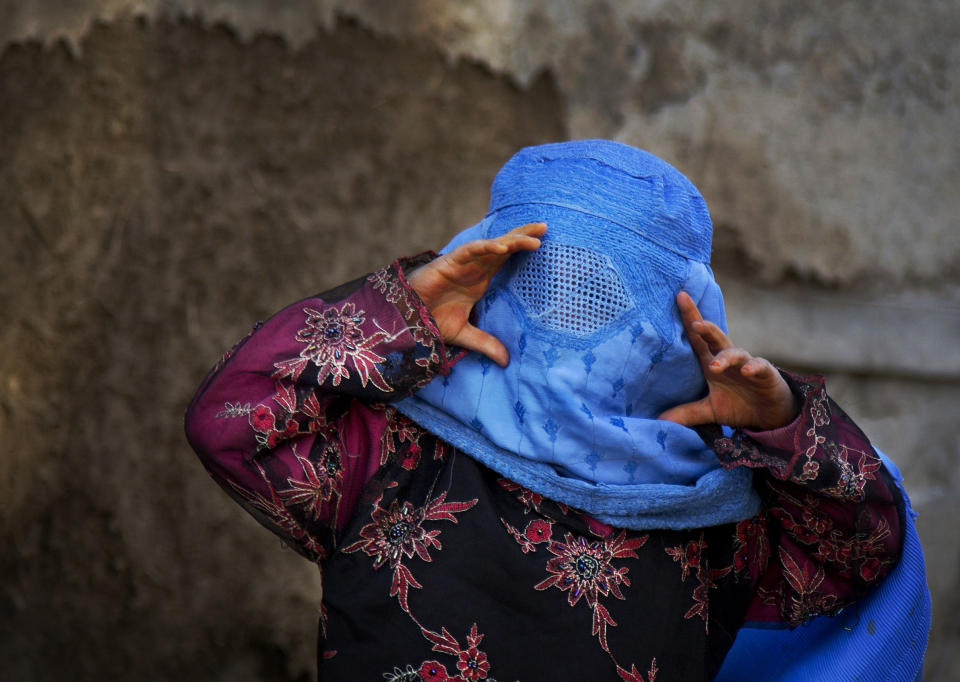 FILE - A girl tries to peer through the holes of her burqa as she plays with other children in the old town of Kabul, Afghanistan, Sunday, April 7, 2013. Despite Associated Press photographer Anja Niedringhaus' reputation as a war photographer, very often she found beauty and joy on assignment. (AP Photo/Anja Niedringhaus, File)