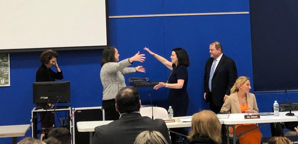 Mendham Township Committee members Tracey Moreen, second from left, and Lauren Spirig hug in celebration following their swearing-in ceremonies during the committee's reorganization at Mendham Township Middle School Thursday, Jan. 5, 2023.