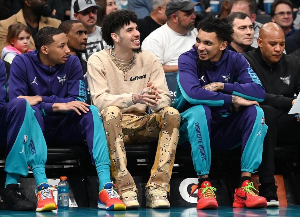 Injured Charlotte Hornets guard LaMelo Ball, center, laughs with guard James Bouknight, right, during the team’s game against the Chicago Bulls on Monday, January 8, 2024 at Spectrum Center in Charlotte, NC.
