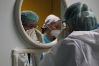 Medical personnel get ready before entering the intensive care unit of the San Filippo Neri hospital in Rome, Thursday, Oct. 29, 2020. San Filippo Neri, the biggest multifunctional public hospital in the northern part of Rome, has currently two pavilions dedicated to COVID-19 patients, and is going to open up a new one as early as Friday. Italy hit another record of confirmed new cases of coronavirus on Thursday, approaching 27,000, a jump of nearly 2,000 in one day. (AP Photo/Alessandra Tarantino)