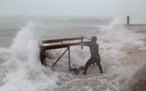 A man tries to salvage a table belonging to his restaurant before the arrival of Hurricane Maria in Punta Cana - Credit: REUTERS/Ricardo Rojas