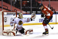 Chicago Blackhawks goaltender Collin Delia (60) knocks the puck over the goal as Florida Panthers center Aleksander Barkov (16) looks on during the second period of an NHL hockey game Sunday, Jan. 17, 2021, in Sunrise, Fla. (AP Photo/Jim Rassol)