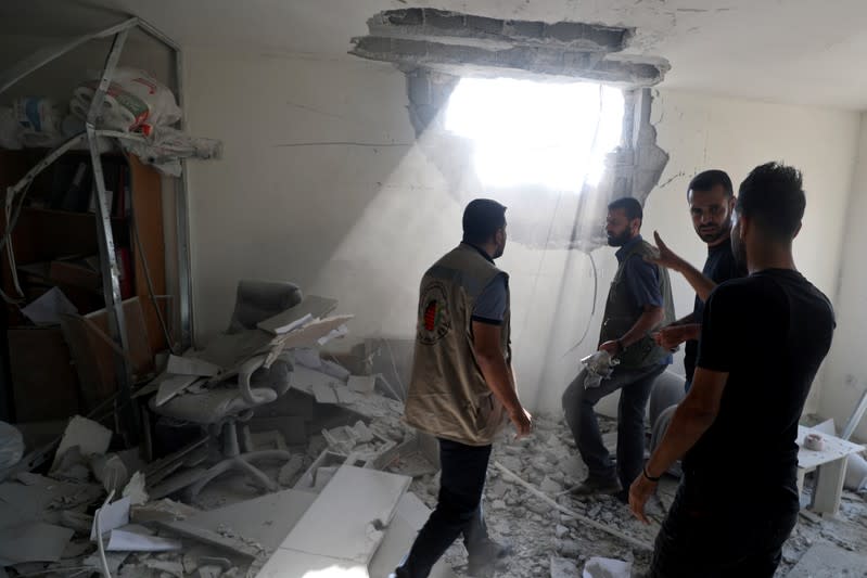 Palestinians inspect a damaged building in Gaza City