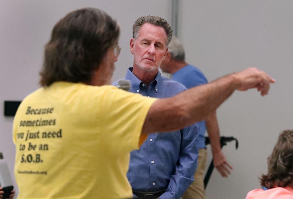 Rob Merrell, a land-use attorney with Cobb Cole Law Firm, listens as beachside resident Paul Zimmerman, left, of the citizens group Sons of the Beach, voices concerns regarding revised plans for a 25-story oceanfront luxury condo-hotel at the east end of Silver Beach Avenue in Daytona Beach.