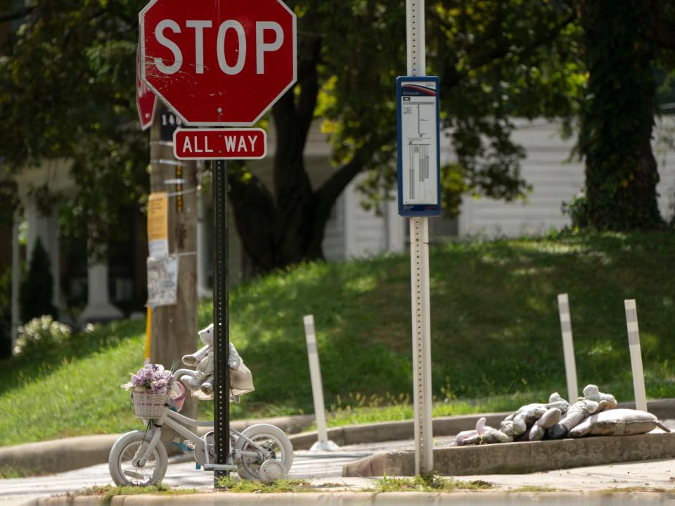 A photo of a stop sign and 5-year-old Allie Hart's tricycle and stuffed animals.