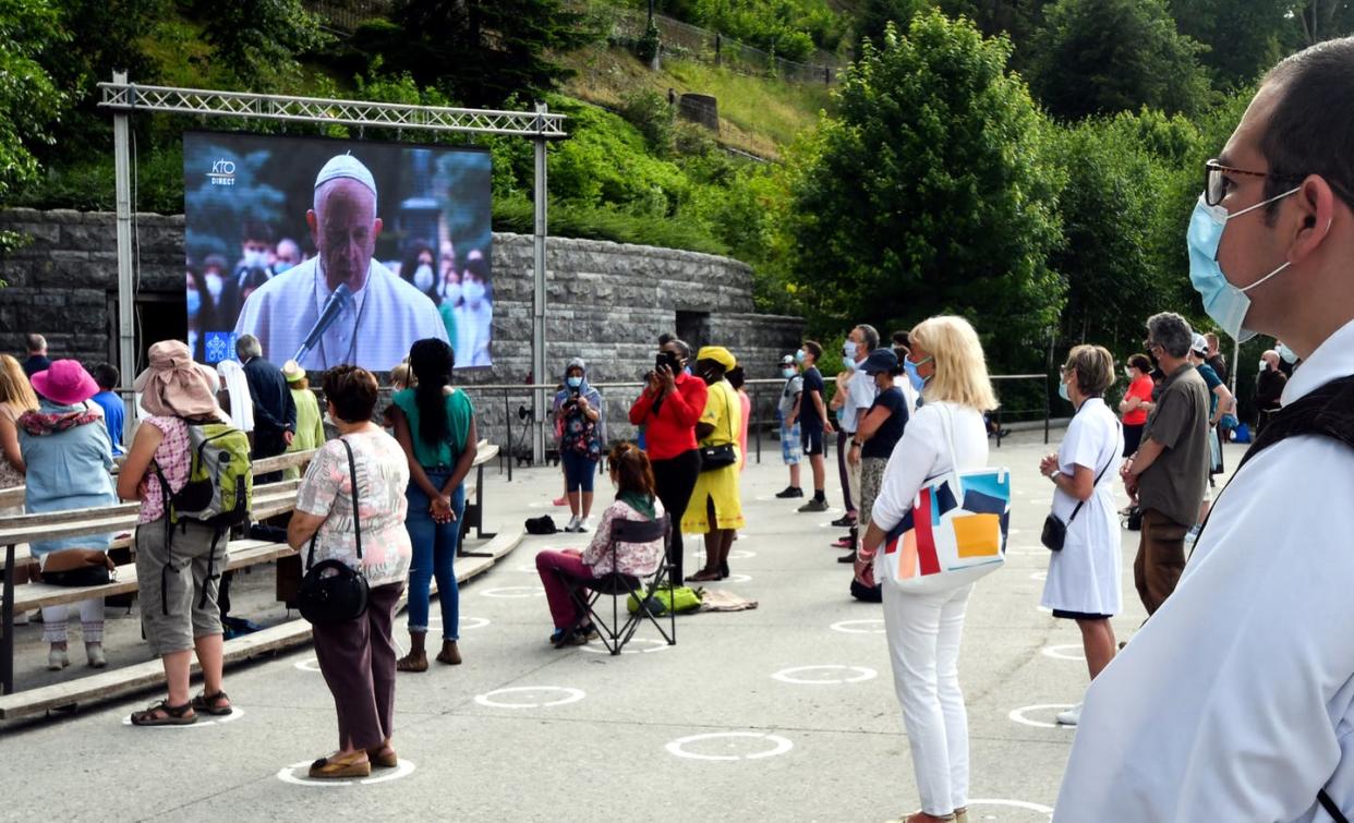 <span class="caption">People wearing masks and social distancing at the Sanctuary of Our Lady of Lourdes on May 30, 2020.</span> <span class="attribution"><a class="link " href="https://www.gettyimages.com/detail/news-photo/faithfuls-wearing-protective-facemasks-sit-and-stand-as-news-photo/1216287453?adppopup=true" rel="nofollow noopener" target="_blank" data-ylk="slk:Laurent Dart/AFP via Getty Images;elm:context_link;itc:0;sec:content-canvas">Laurent Dart/AFP via Getty Images</a></span>