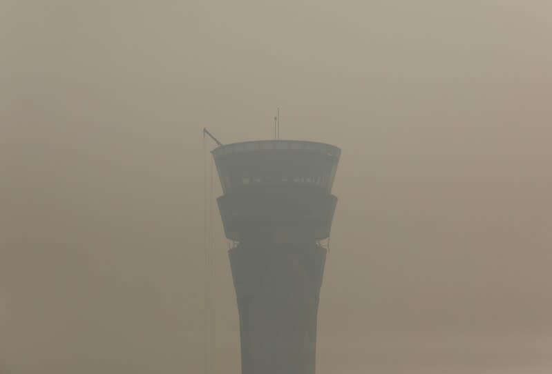 An air traffic control tower is pictured on a smoggy morning at the Indira Gandhi International Airport in New Delhi