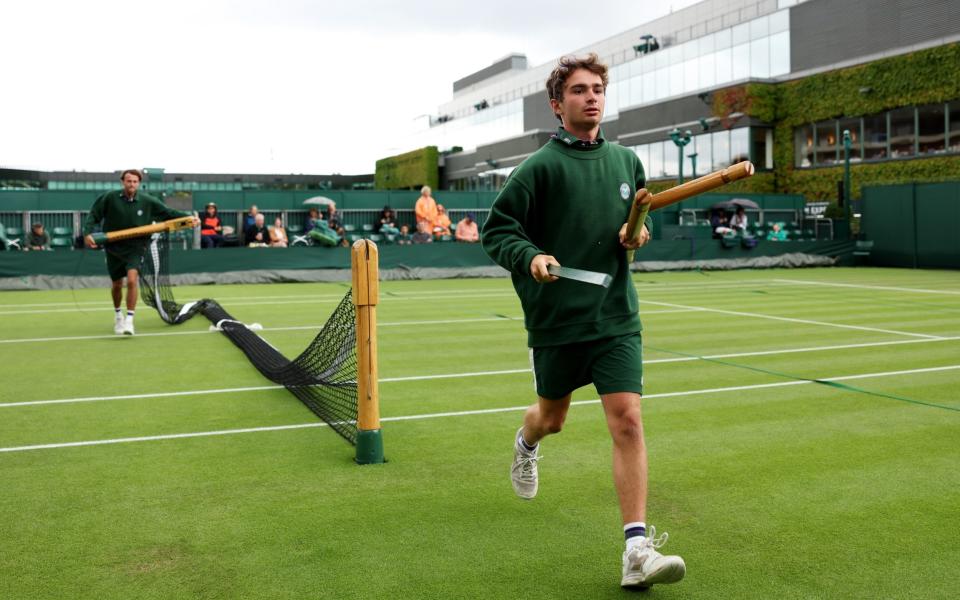 El personal de tierra se prepara para sacar las cubiertas de lluvia durante el tercer día del Campeonato de Wimbledon 2023 en el All England Lawn Tennis and Croquet Club el 5 de julio de 2023 en Londres, Inglaterra.