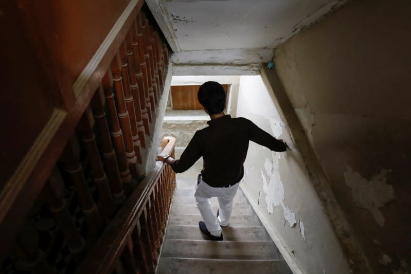 A typhoid fever survivor descends a set of stairs at his family home in Karachi,