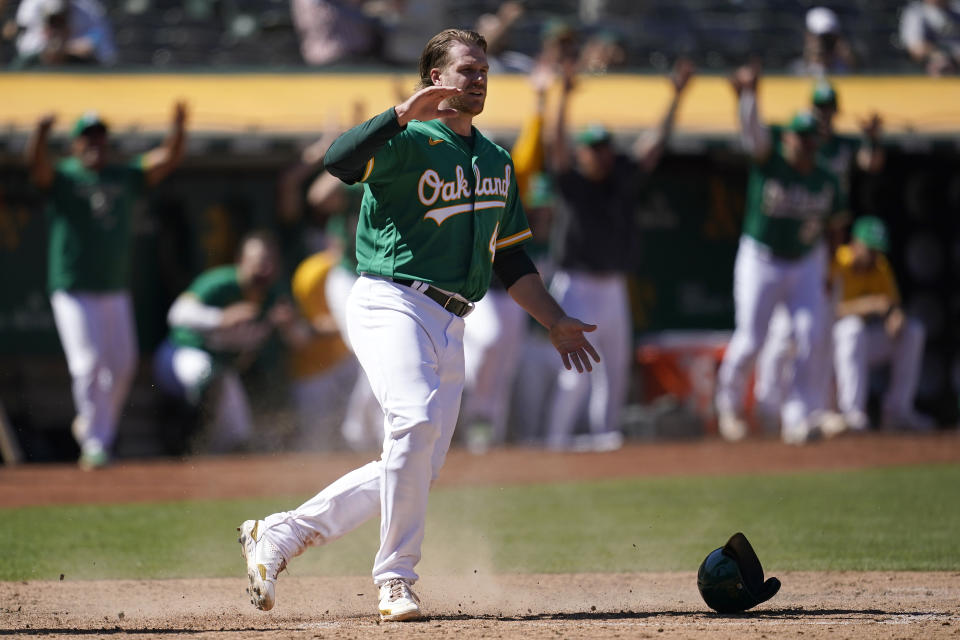 Oakland Athletics' David MacKinnon celebrates after scoring on a Skye Bolt sacrifice fly during the 10th inning of a baseball game against the Miami Marlins in Oakland, Calif., Wednesday, Aug. 24, 2022. (AP Photo/Jeff Chiu)