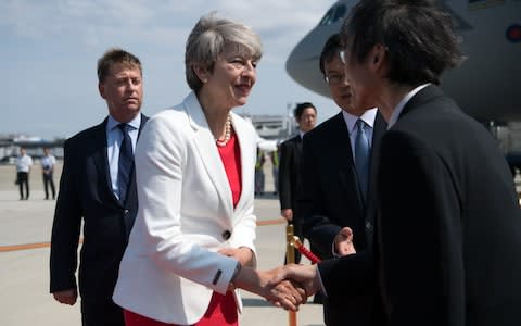 Prime Minister Theresa May is greeted by dignitaries as she arrives in Japan - Credit: Getty