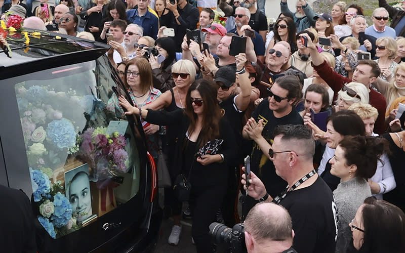 Fans of Sinéad O'Connor line the street as her funeral cortege passes