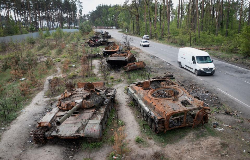 Autos fahren an zerstörten russischen Panzern in der Nähe von Kiew, Ukraine, im Mai 2022 vorbei. - Copyright: AP Photo/Efrem Lukatsky