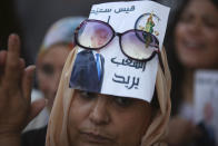 A supporter of independent Tunisian Presidential candidate Kais Saied attends a rally on the last day of campaigning before the second round of the presidential elections, in Tunis, Tunisia, Friday, Oct. 11, 2019. Poster in Arabic shows the number and slogan of Kais "People's wish." (AP Photo/Mosa'ab Elshamy)