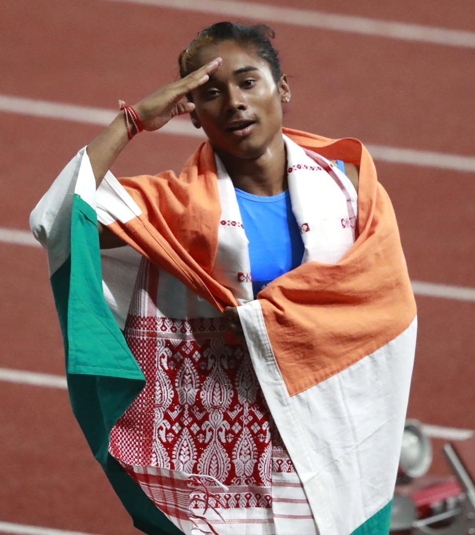 India's Hima Das celebrates after her second place finish in the women's 400m final during the athletics competition at the 18th Asian Games at Gelora Bung Karno Stadium in Jakarta, Indonesia, Sunday, Aug. 26, 2018. (AP Photo/Dita Alangkara)