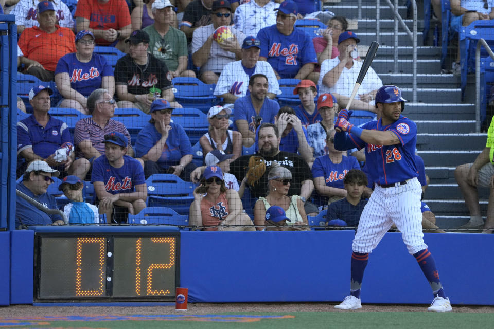 New York Mets' Tommy Pham stands in the on-deck circle as a pitch clock counts down during the sixth inning of a spring training baseball game against the Washington Nationals Sunday, Feb. 26, 2023, in Port St. Lucie, Fla. (AP Photo/Jeff Roberson)