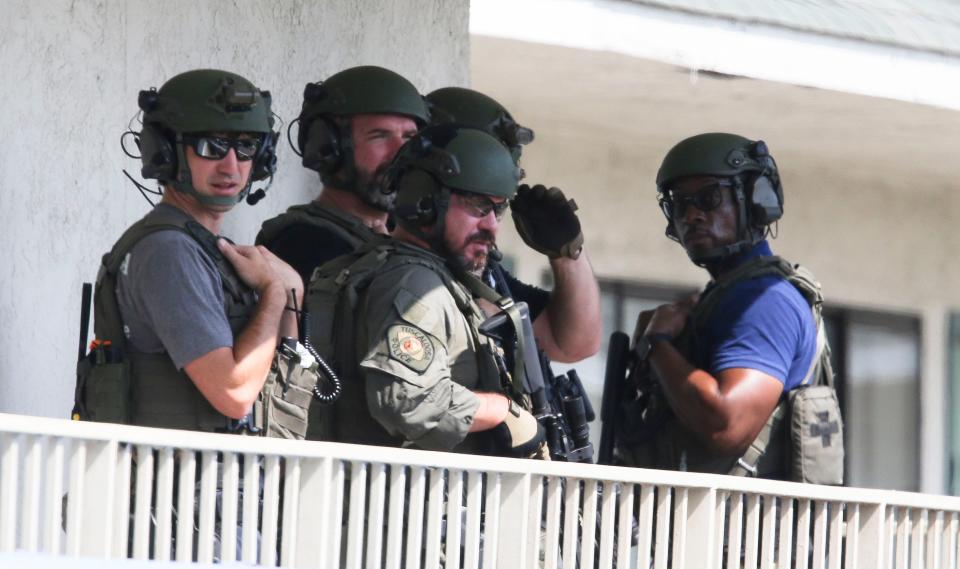 Well armed Tuscaloosa Police officers stand ready at the Motel 6 on McFarland Blvd. East where a pair of armed men broke into a hotel room early Monday morning, Aug. 9, 2021. One suspect is in custody, the other is in the room, refusing to surrender. A dog was shot during the invasion according to police. [Staff Photo/Gary Cosby Jr.]
