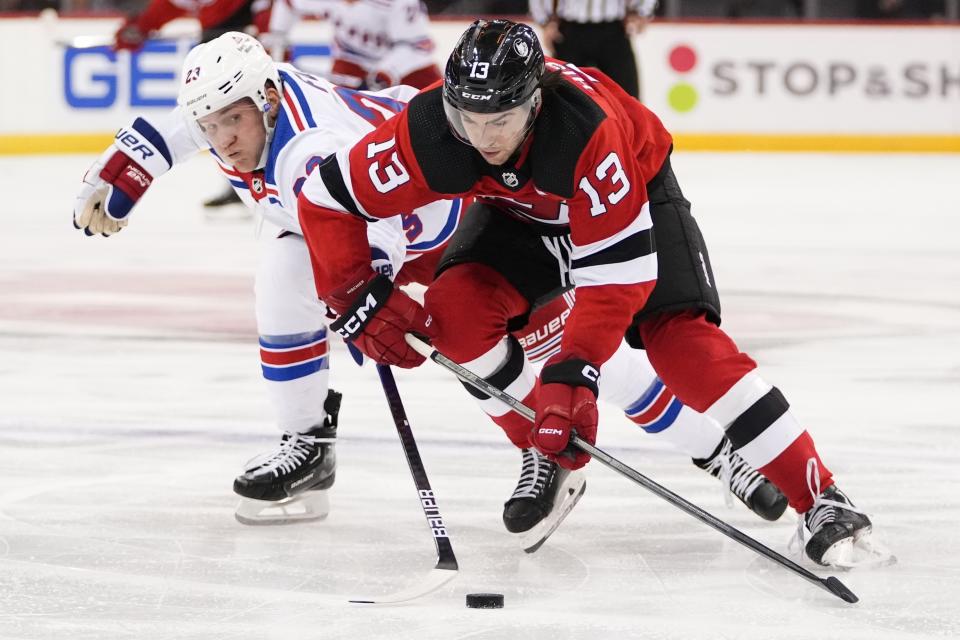 New York Rangers' Adam Fox (23) competes for control of the puck against New Jersey Devils' Nico Hischier (13) during the second period of an NHL preseason hockey game Wednesday, Oct. 4, 2023, in Newark, N.J. (AP Photo/Frank Franklin II)