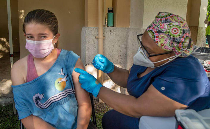 Eva Mcaliley, 12, gets her first COVID-19 vaccine shot from Nurse Katiana Legagneur 