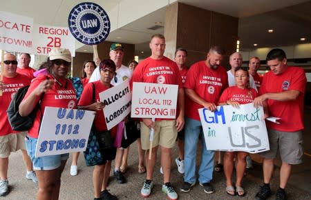 Auto workers from the General Motors Lordstown assembly plant stop to be photographed while protesting GM plant closings outside General Motors World Headquarters in Detroit,