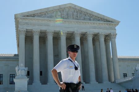 A police officer stands outside the U.S. Supreme Court building after the Court sided with Trinity Lutheran Church, which objected to being denied public money in Missouri, in Washington, U.S., June 26, 2017. REUTERS/Yuri Gripas