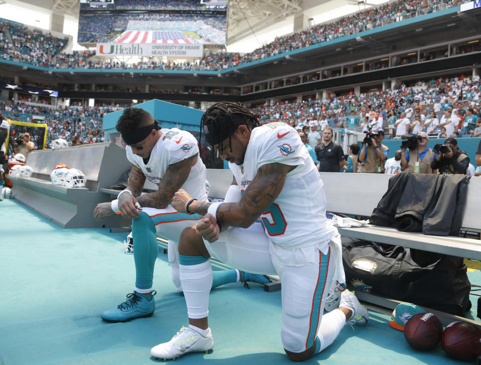 Miami Dolphins wide receiver Kenny Stills (10) and Miami Dolphins wide receiver Albert Wilson (15) kneel during the national anthem before an NFL football game against the Tennessee Titans, Sunday, Sept. 9, 2018, in Miami Gardens, Fla. (AP Photo/Wilfredo Lee)