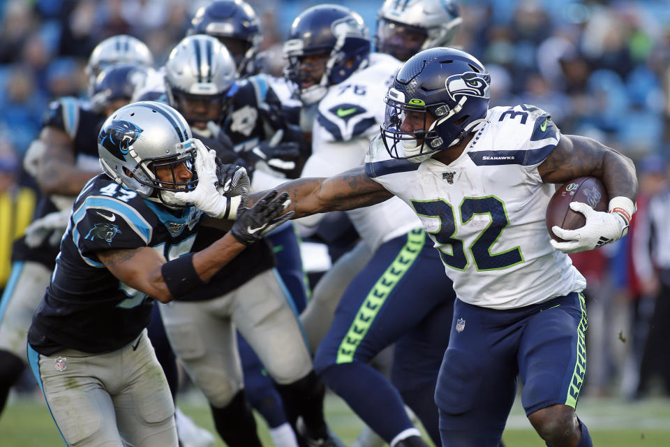 Seattle Seahawks running back Chris Carson (32) runs while Carolina Panthers defensive back Ross Cockrell (47) chases during the second half of an NFL football game in Charlotte, N.C., Sunday, Dec. 15, 2019. (AP Photo/Brian Blanco)