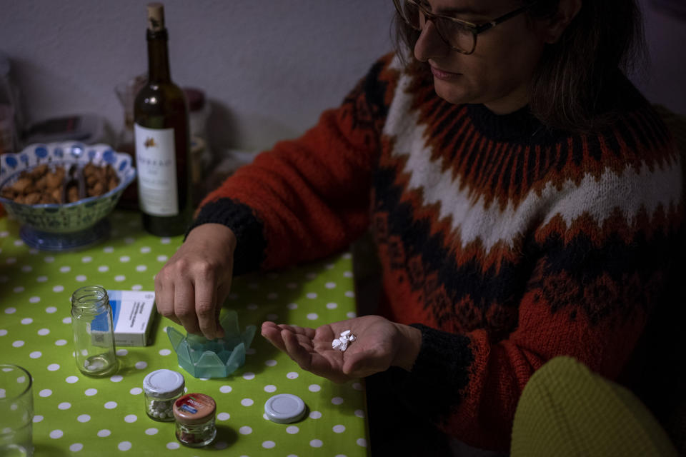 Victoria Martinez, 44, takes her daily doses of hormones at her home in Barcelona, Spain, Monday, Feb. 8, 2021. By May this year, barring any surprises, Martinez will complete a change of both gender and identity at a civil registry in Barcelona, finally closing a patience-wearing chapter that has been stretched during the pandemic. The process, in her own words, has also been “humiliating.”(AP Photo/Emilio Morenatti)