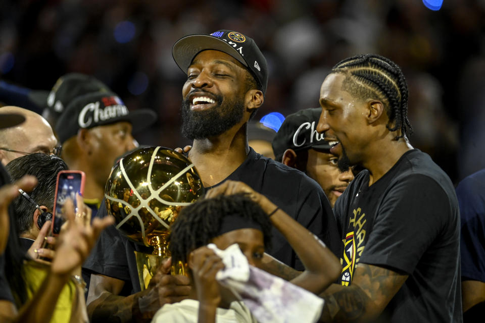 Jeff Green holds the Larry O'Brien Championship Trophy as Kentavious Caldwell-Pope (5) celebrates after the Nuggets won the NBA championship at Ball Arena in Denver on June 12, 2023. (AAron Ontiveroz/The Denver Post)