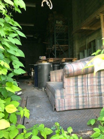 Some of the hazardous waste materials found at the former Quality Chemical brownfield site at 209-217 S. 21st St. in Newark, next to a couch used by homeless individuals seeking shelter.