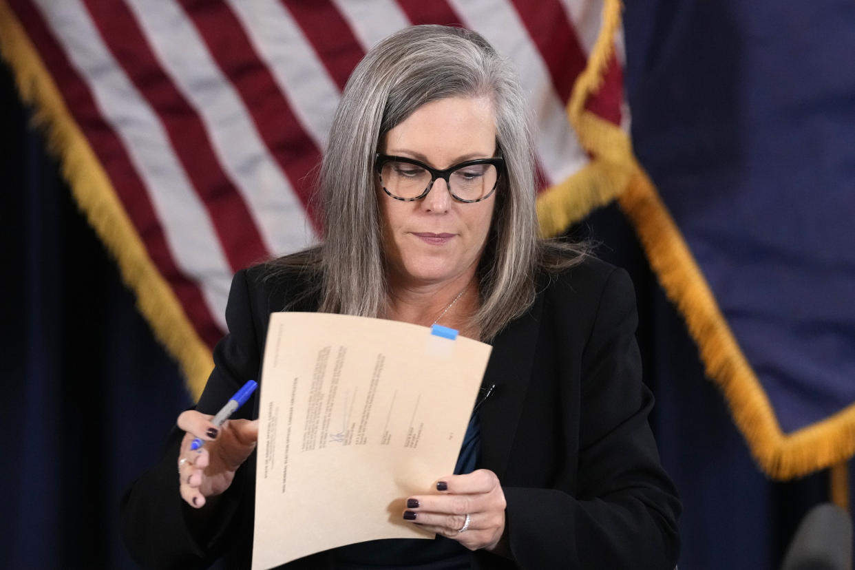 Arizona Democrat governor-elect and current Arizona Secretary or State Katie Hobbs signs the official certification for the Arizona general election canvass during a ceremony at the Arizona Capitol in Phoenix, Monday, Dec. 5, 2022. (AP Photo/Ross D. Franklin, Pool)