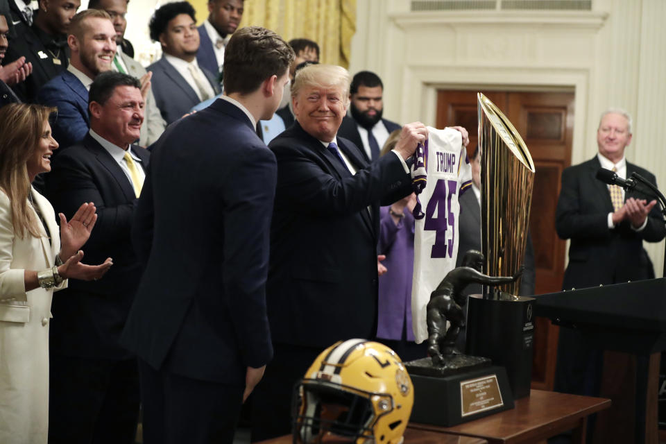 President Donald Trump is presented with a jersey from Louisiana State University Tigers quarterback Joe Burrow during an event to honor the 2019 NCAA football national champions, the Louisiana State University Tigers, in the East Room of the White House, Friday, Jan. 17, 2020, in Washington. (AP Photo/ Evan Vucci)