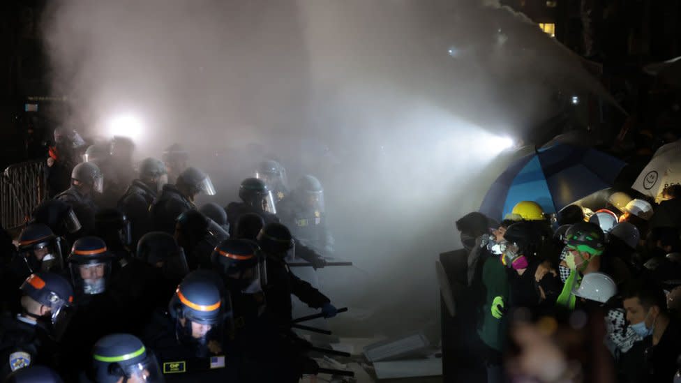 Police officers clash with pro-Palestinian protesters as a fire extinguisher is deployed at UCLA early Thursday morning