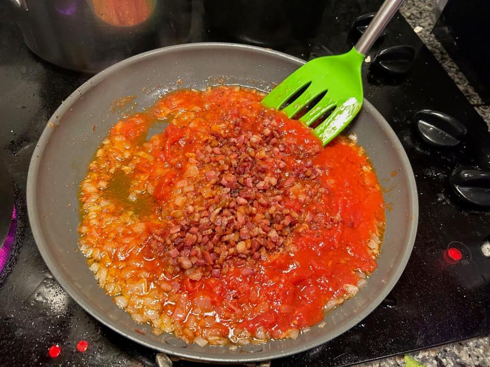 Adding tomatoes for Giada De Laurentiis' Bucatini All'Amatriciana pasta