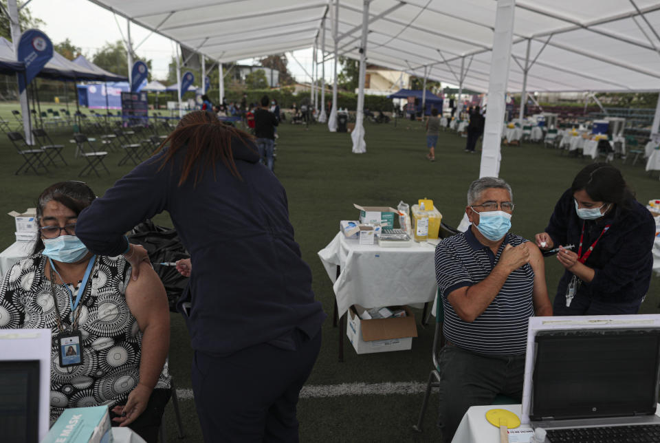 Trabajadores de la salud aplican la vacuna Sinovac para el COVID-19 en el Complejo Deportivo La Pintana convertido en un sitio de vacunación improvisado en Santiago, Chile, el jueves 11 de marzo de 2021. (AP Foto/Esteban Félix)