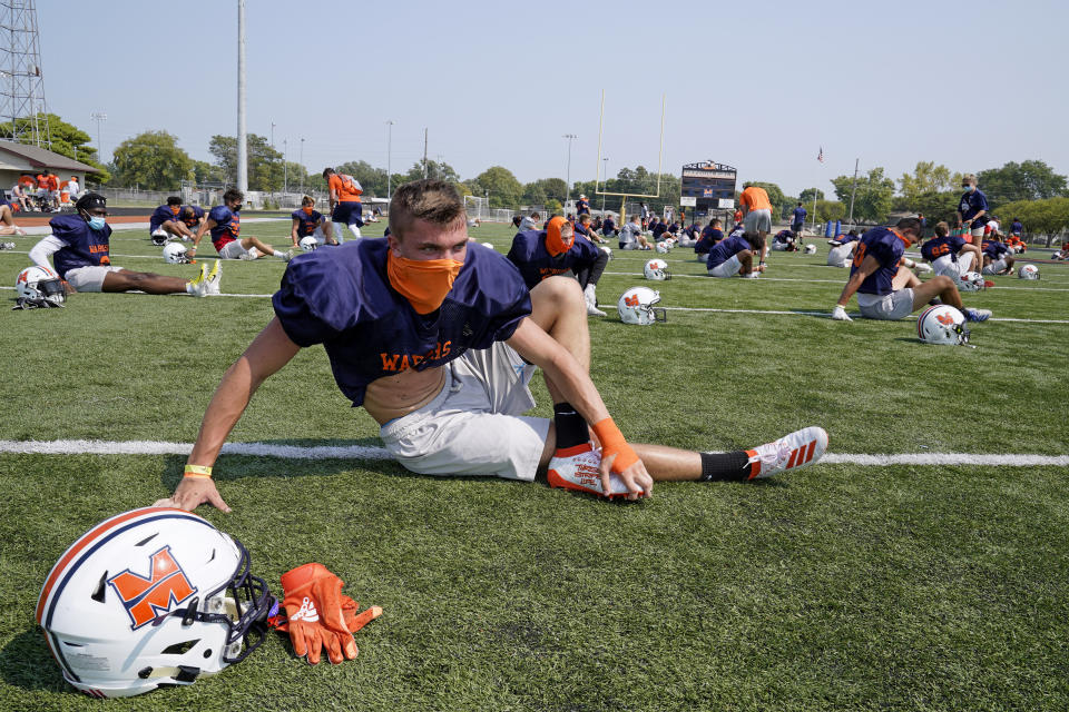 Midland University NAIA college football players wear face masks during practice in Fremont, Neb., Tuesday, Aug. 25, 2020. Midland University is among five small colleges in the state that are pushing forward with plans to play football this fall. The Nebraska Cornhuskers, meanwhile, won't play after Big Ten presidents voted to move back football season until after Jan. 1. (AP Photo/Nati Harnik)