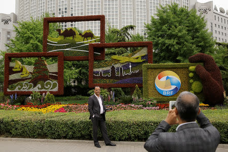 People take pictures in front of a flower arrangement set up to mark the upcoming Belt and Road Forum in Beijing, China April 19, 2019. Picture taken April 19, 2019. REUTERS/Thomas Peter