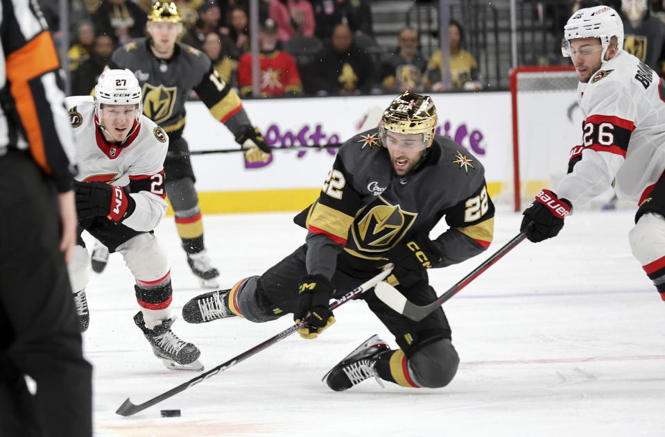 Vegas Golden Knights right wing Michael Amadio (22) is tripped between Ottawa Senators left wing Parker Kelly (27) and defenseman Erik Brannstrom (26) during the second period of an NHL hockey game Sunday, Dec. 17, 2023, in Las Vegas. Brannstrom was penalized on the play. (AP Photo/Steve Marcus)