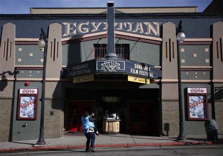 A woman uses a mobile phone to take pictures of the Egyptian Theater before the opening day of the Sundance Film Festival in Park City, Utah, January 15, 2014. REUTERS/Jim Urquhart