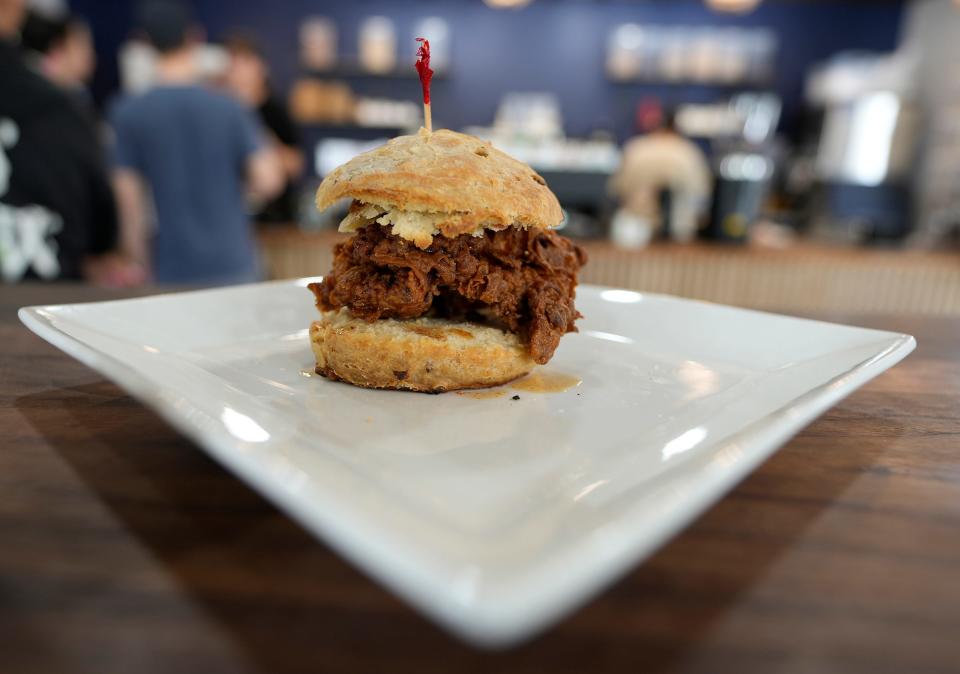 The chicken and biscuit sandwich at Trilogy Kitchen includes fried buttermilk chicken drizzled with cayenne maple syrup on a maple bacon biscuit.