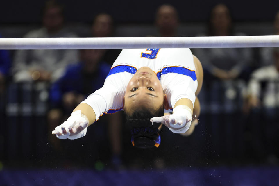 FILE - Florida's Leanne Wong competes on the uneven bars during an NCAA gymnastics meet against Georgia on Friday, Jan. 27, 2023, in Gainesville, Fla. Wong has six perfect 10s in her career and four this season, part of a massive surge of 10s being awarded at the NCAA level that has some in the sport wondering if they are being given out too often. (AP Photo/Gary McCullough, File)