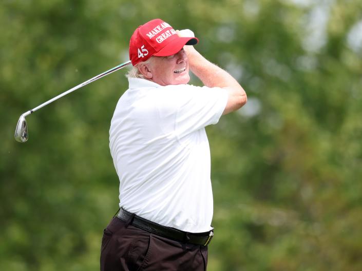Donald Trump swinging a golf club.