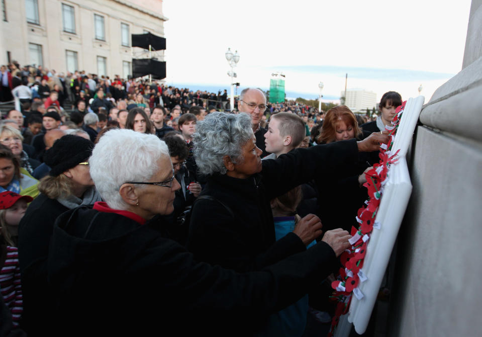 People place poppies on the Cenotaph at the Auckland War Memorial Museum during the ANZAC Day Dawn Service on April 25, 2012 in Auckland, New Zealand. Veterans, dignitaries and members of the public today marked ANZAC (Australia New Zealand Army Corps) Day, when First World War troops landed on the Gallipoli Peninsula, Turkey early April 25, 1915, commemorating the event with ceremonies of remembrance for those who fought and died in all wars. (Photo by Phil Walter/Getty Images)