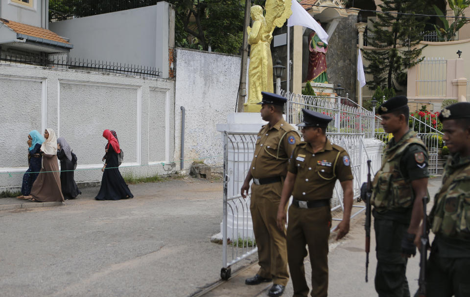 In this Sunday, May 12, 2019, photo, Sri Lankan soldiers watch as a group of Muslim students walk past a closed catholic convent in Colombo, Sri Lanka. Catholic officials and parents in Sri Lanka are hopeful that church-run schools will begin to reopen soon for the first time since April’s devastating Easter Sunday attacks on churches and hotels. (AP Photo/Eranga Jayawardena)
