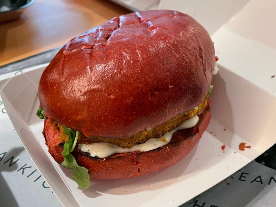 Picture of plant-based chicken burger in a beetroot bun.