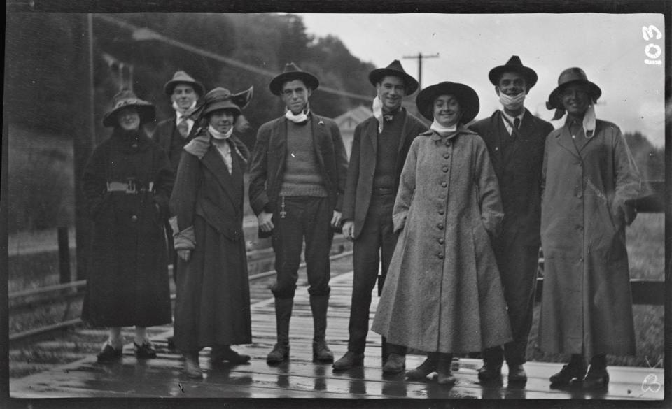 Members of "Hash and Eggers" hiking group pose for a group picture at a train station in Mill Valley, California, briefly removing their cloth masks. The photo was taken by fellow member Raymond Coyne during the first peak of the Spanish flu, November 1918.