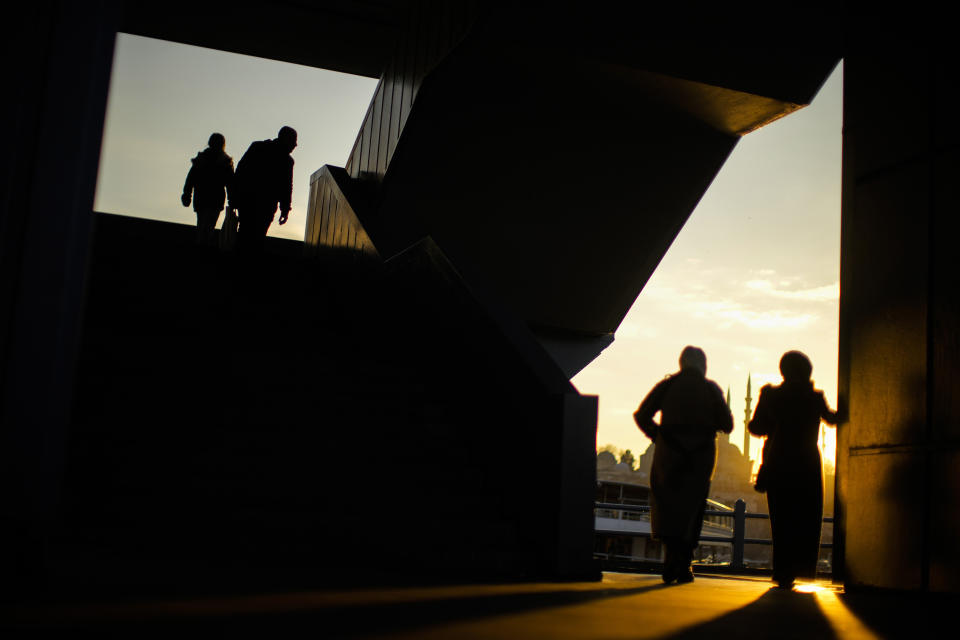 Passers-by walk at Galata bridge in Istanbul, Turkey, Wednesday, Feb. 1, 2023. (AP Photo/Francisco Seco)