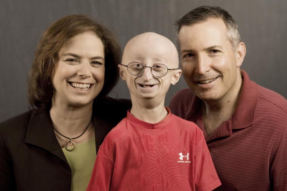 This undated photo provided by HBO shows Sam Berns, the subject of the HBO documentary, "Life According to Sam," center, with his parents, Leslie Gordon, left, and Scott Berns. Sam Berns, 17, died Friday, Jan. 10, 2014 of complications from Hutchinson-Gilford progeria syndrome, commonly known as progeria. Hundreds of people, including New England Patriots owner Robert Kraft, attended his funeral on Tuesday, Jan. 14, 2014. (AP Photo/HBO, Sean Fine)