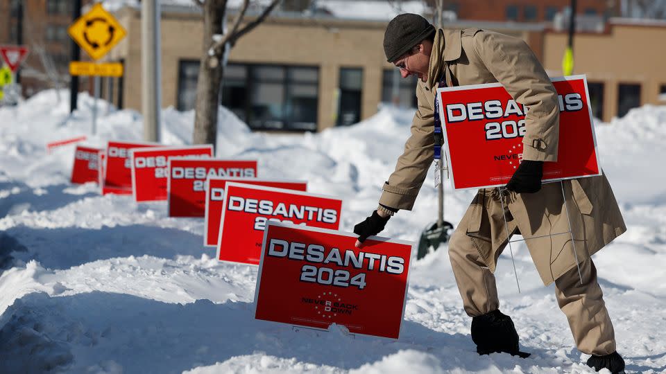 A volunteer plunges signs for DeSantis into deep snow outside the Chrome Horse Saloon one day before the 2024 Iowa caucuses in Cedar Rapids. - Chip Somodevilla/Getty Images