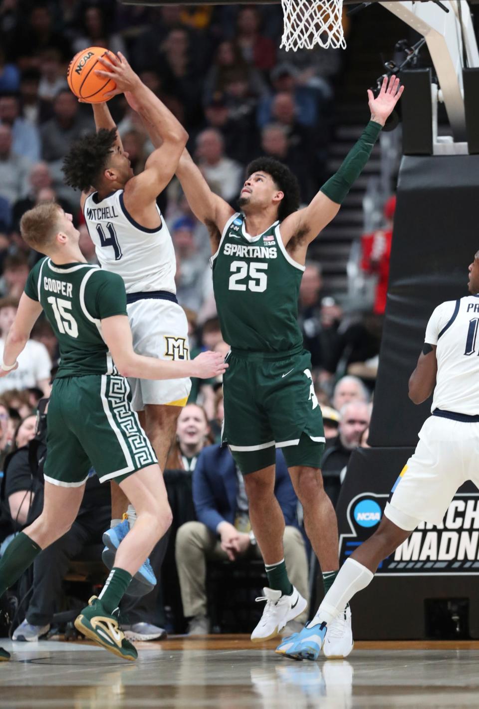 Michigan State Spartans center Carson Cooper and  forward Malik Hall defend Marquette Golden Eagles guard Stevie Mitchell during the first half in the second round of the NCAA tournament Sunday, March 19, 2023 in Columbus, Ohio.